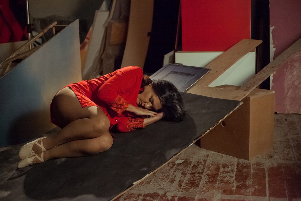 A dançarina protagonista Rosa Muller deitada em posição fetal, encenando em Zona de Desconforto. Fotografia Vinícius Sampaio. Natal SESC Quitandinha.