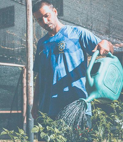 O Rapper petropolitano Matheus Lima Teko regando plantas em seu sítio.